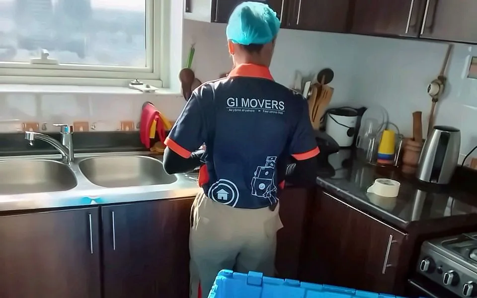 GI Movers crew packing a kitchen in a high-rise apartment