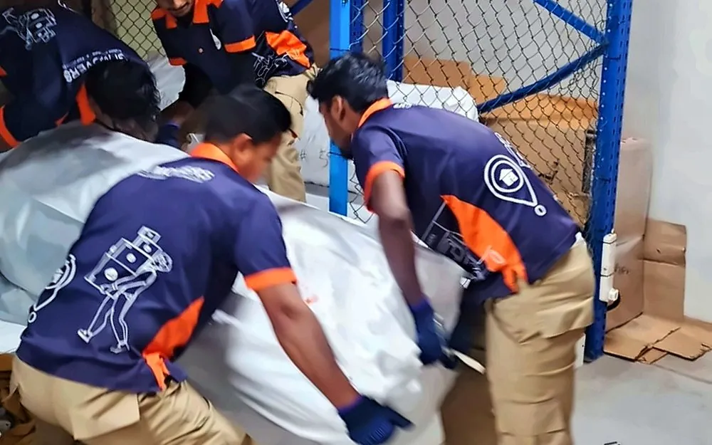 GI Movers crew export-packing furniture at the warehouse