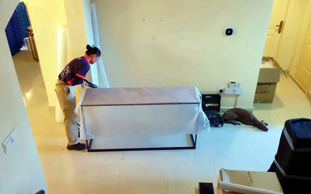 GI Movers crew wrapping furniture in a villa