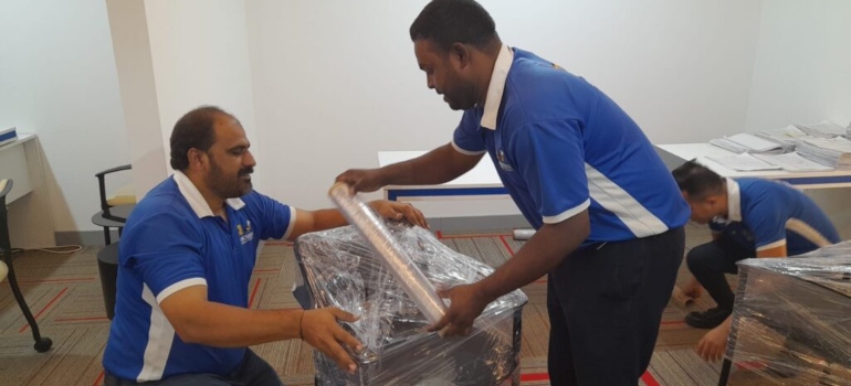 GI Movers team wrapping furniture for moving from Dubai to Abu Dhabi