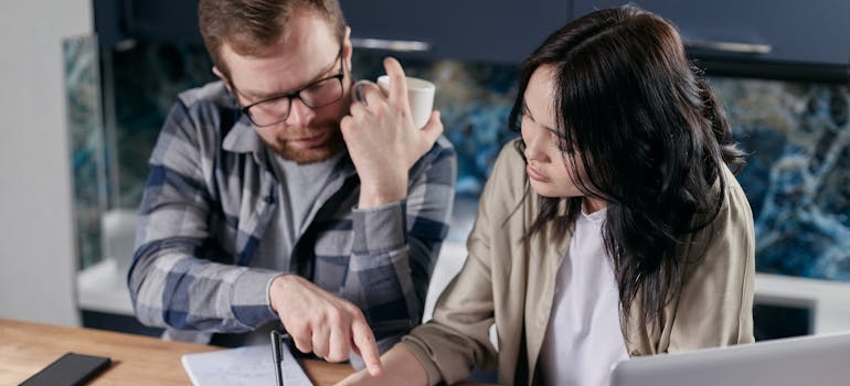 two people calculating to try to cut costs on moving services