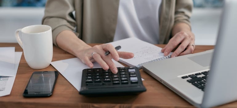 a person calculating in order to plan for everyday expenses in Dubai