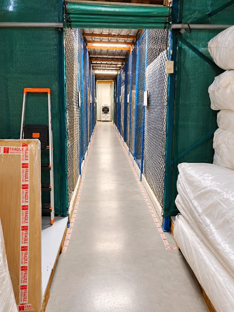 Climate-controlled storage aisle with wrapped mattresses at GI Movers